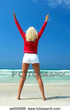 Stock Photograph - Arms raised, beach, back view, Arms open. Fotosearch