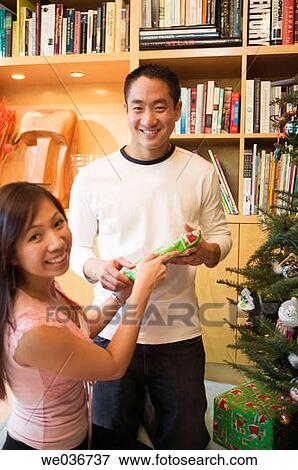 Asian couple with Christmas gifts View Large Photo Image Stock Photo - Asian couple with Christmas gifts. Fotosearch
