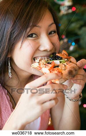Asian woman eating pizza View Large Photo Image Stock Photo - Asian woman eating pizza. Fotosearch