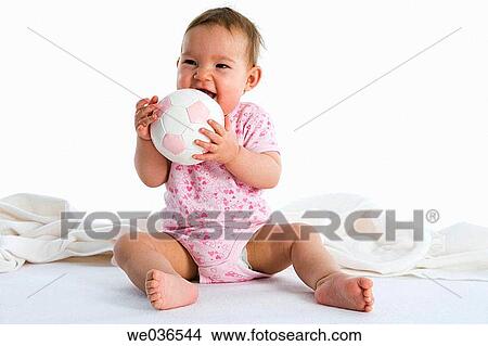 Baby sitting on the floor with a ball View Large Photo Image Picture - Baby sitting on the floor with a ball. Fotosearch