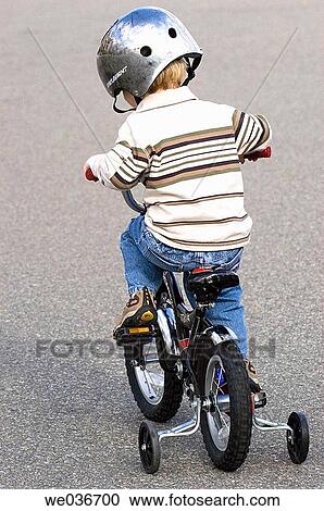 Boy riding bike with training wheels View Large Photo Image Stock Image - Boy riding bike with training wheels. Fotosearch