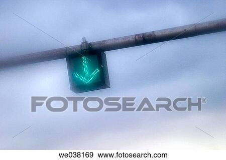 Green traffic arrow hanging over a city street View Large Photo Image Stock Photo - Green traffic arrow hanging over a city street. Fotosearch