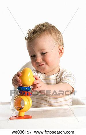 Little boy playing with a plastic rattle doll View Large Photo Image Stock Photo - Little boy playing with a plastic rattle doll. Fotosearch