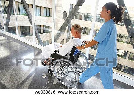 Nurse pushing patient in wheelchair View Large Photo Image Stock Photograph - Nurse pushing patient in wheelchair. Fotosearch