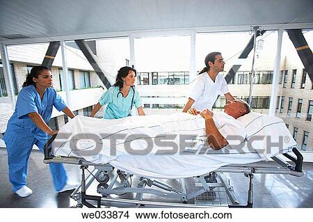 Nurses carrying patient View Large Photo Image Picture - Nurses carrying patient. Fotosearch