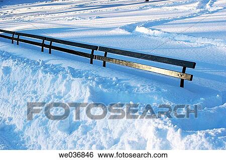Stock Photograph - Park benches buried in a storm in Central Park, Manhattan. Fotosearch