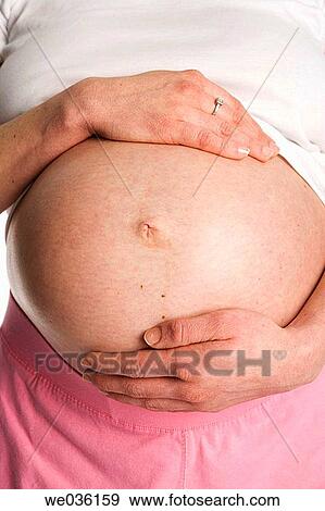 Pregnant belly with hands View Large Photo Image Stock Photo - Pregnant belly with hands. Fotosearch