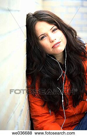 Stock Photo - Sexy 30's caucasian woman leaning on wall and smiling in camera. Fotosearch