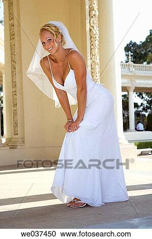 Smiling bride poses flirtingly View Large Photo Image Stock Image - Smiling bride poses flirtingly. Fotosearch