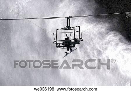 Snowboarder on ski lift View Large Photo Image Stock Photo - Snowboarder on ski lift. Fotosearch