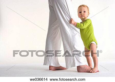 Toddler standing near his mothers legs View Large Photo Image Picture - Toddler standing near his mothers legs. Fotosearch