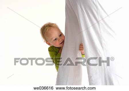 Toddler standing near his mothers legs View Large Photo Image Stock Photograph - Toddler standing near his mothers legs. Fotosearch