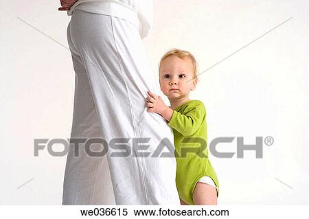 Toddler standing near his mothers legs View Large Photo Image Stock Photography - Toddler standing near his mothers legs. Fotosearch