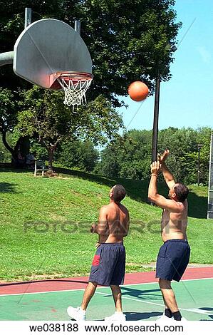 Two middle-age Spanish men playing basketball at a local park View Large Photo Image Stock Photo - Two middle-age Spanish men playing basketball at a local park. Fotosearch