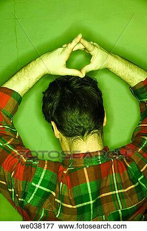 Young man, with his hands over his head, posing with his back to the camera View Large Photo Image Stock Photo - Young man, with his hands over his head, posing with his back to the camera. Fotosearch
