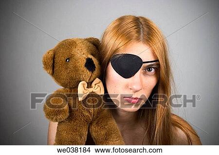 Young woman, with long red hair, wearing an eye patch and holding a stuffed animal on her shoulder View Large Photo Image Picture - Young woman, with long red hair, wearing an eye patch and holding a stuffed animal on her shoulder. Fotosearch