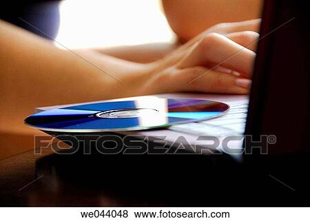 20 years old girl typing/working on laptop computer with CD/disc on laptop. View Large Photo Image Stock Photo - 20 years old girl typing/working on laptop computer with CD/disc on laptop.. Fotosearch