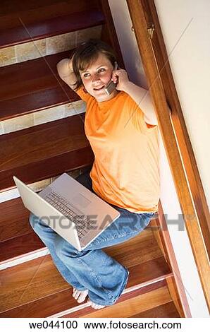 Stock Image - 30's, calling, barefoot, at-home, 20's. Fotosearch