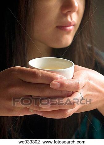 Asian female holding a cup of Chinese tea with both hands. View Large Photo Image Stock Image - Asian female holding a cup of Chinese tea with both hands.. Fotosearch