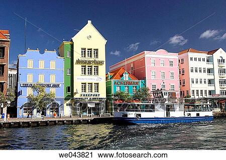 Stock Image - Brightly colored buildings with Dutch colonial architecture line the port in Willemstad, Curacao, Netherland Antilles.. Fotosearch