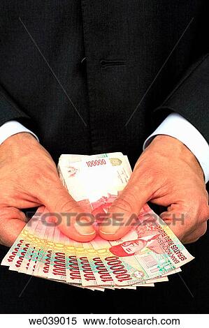 Business man holding 100. 000 Indonesian Rupiah notes in his hands View Large Photo Image Stock Photography - Business man holding 100. 000 Indonesian Rupiah notes in his hands. Fotosearch