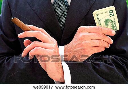 Business man holding 20 Dollar notes and cigar View Large Photo Image Stock Photo - Business man holding 20 Dollar notes and cigar. Fotosearch