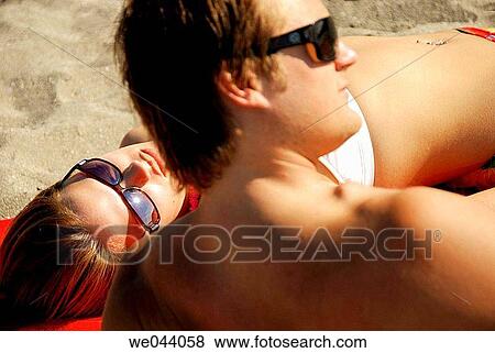 Stock Photo - couple laying on beach together. Fotosearch
