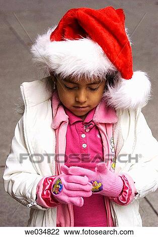 Stock Image - Latin girl with Santa Claus hat. Fotosearch