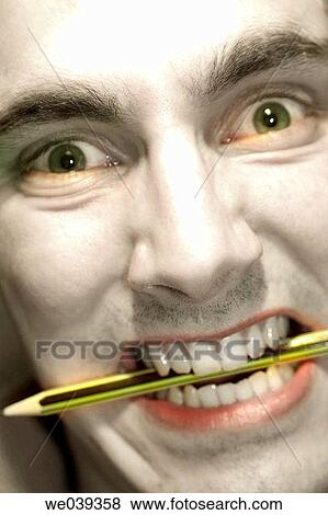 Man biting a pencil View Large Photo Image Stock Photo - Man biting a pencil. Fotosearch