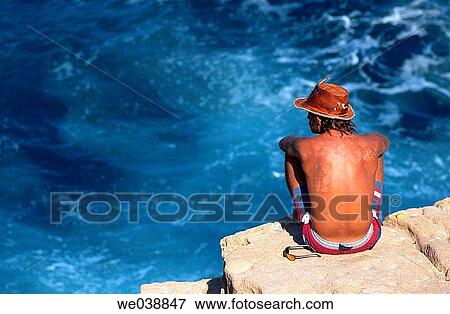 Man sunbathing on a cliff View Large Photo Image Stock Photo - Man sunbathing on a cliff. Fotosearch