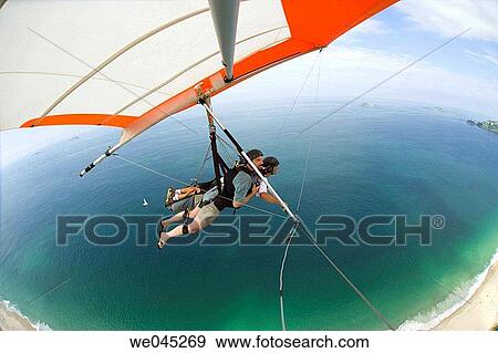 Stock Photo - Tandem hangliders, taking off from Pedro Bonita mountain, landing on Pepino Beach, South end of Rio de Janiero, Brazil. Fotosearch