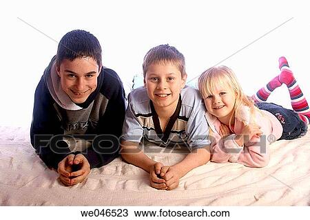 14, 12 and 4 year olds siblings, lying together on their tummies on the floor, smiling into camera View Large Photo Image Stock Image - 14, 12 and 4 year olds siblings, lying together on their tummies on the floor, smiling into camera. Fotosearch