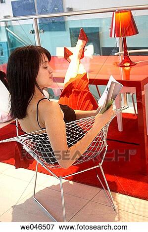 21 year old girl sitting at a desk wearing red shoes, skirt at a red table with book View Large Photo Image Stock Photo - 21 year old girl sitting at a desk wearing red shoes, skirt at a red table with book. Fotosearch