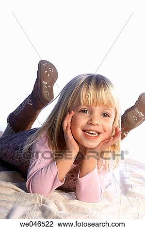 4 year old girl lying on her tummy chin in her hands, smiling off camera View Large Photo Image Stock Image - 4 year old girl lying on her tummy chin in her hands, smiling off camera. Fotosearch