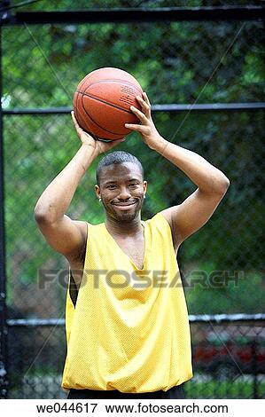 African-American man holding a basketball over his head and looking into camera View Large Photo Image Stock Photo - African-American man holding a basketball over his head and looking into camera. Fotosearch