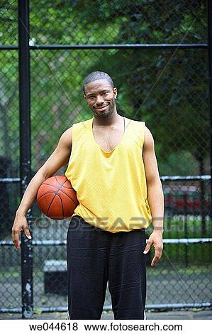 African-American man looking into camera with basketball under his arm View Large Photo Image Stock Photo - African-American man looking into camera with basketball under his arm. Fotosearch
