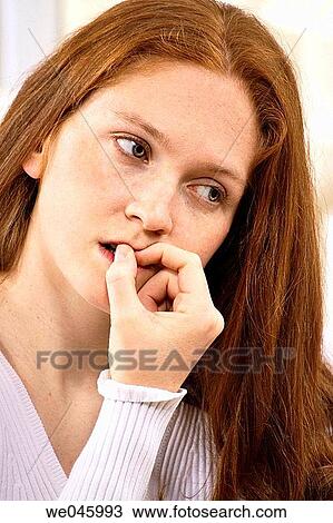 Stock Image - Biting nails, Close-up, absorbed. Fotosearch