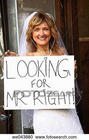 Bride holding sign? Looking for Mr. Right? View Large Photo Image Stock Image - Bride holding sign? Looking for Mr. Right?. Fotosearch