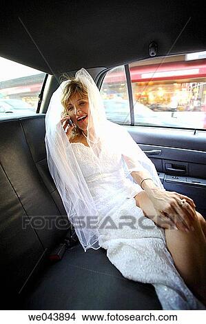 Bride in back of taxi cab talking on cell phone View Large Photo Image Picture - Bride in back of taxi cab talking on cell phone. Fotosearch