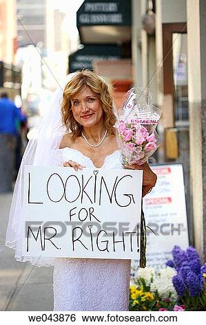 Stock Photograph - Bride on street with sign? Looking for Mr. Right?. Fotosearch
