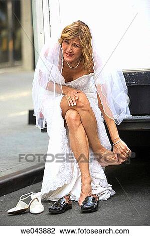 Bride sitting on bumper of truck massaging her aching feet View Large Photo Image Stock Image - Bride sitting on bumper of truck massaging her aching feet. Fotosearch