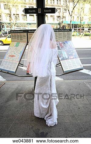 Bride with back to camera reading street map View Large Photo Image Stock Image - Bride with back to camera reading street map. Fotosearch