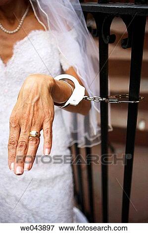 Brides hand handcuffed to fence View Large Photo Image Stock Photo - Brides hand handcuffed to fence. Fotosearch