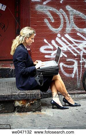 Business woman working outside with laptop against graffiti wall View Large Photo Image Stock Image - Business woman working outside with laptop against graffiti wall. Fotosearch