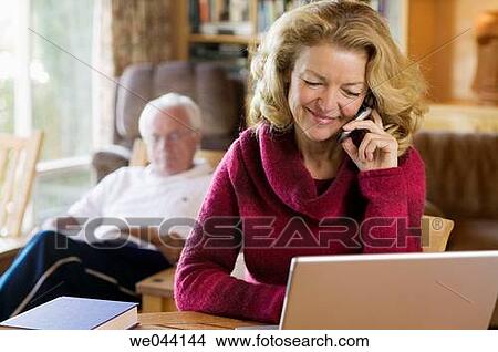 Picture - calling, cell phone, at-home. Fotosearch