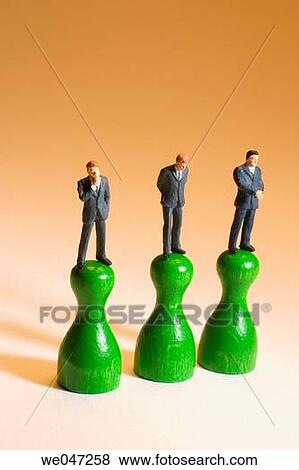 Miniature Businessmen on Game Pieces View Large Photo Image Stock Photo - Miniature Businessmen on Game Pieces. Fotosearch