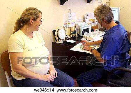 Pregnant 30 something year old mum at the doctors surgery having her pre natal checkup with the midwife View Large Photo Image Picture - Pregnant 30 something year old mum at the doctors surgery having her pre natal checkup with the midwife. Fotosearch