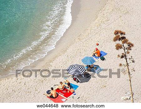 Sunbathers on Caletilla beach. Nerja, Costa del Sol, Malaga province, Andalusia, Spain View Large Photo Image Stock Photo - Sunbathers on Caletilla beach. Nerja, Costa del Sol, Malaga province, Andalusia, Spain. Fotosearch