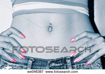 Stock Photo - Thailand, Bangkok, girl's belly button with piercing and hands with red fingernails, wearing jeans. Fotosearch