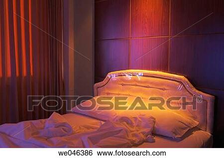 Thailand, Bangkok, hotel bed in the evening lit by ceiling lamp and tv View Large Photo Image Stock Photograph - Thailand, Bangkok, hotel bed in the evening lit by ceiling lamp and tv. Fotosearch
